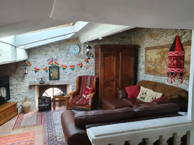 a living room with a couch and a stone wall at Maison Carrasserie in Limoux