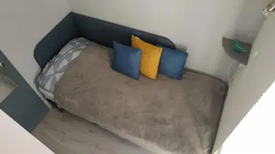 a bed with three pillows on it in a room at Saphir de Gruissan in Gruissan