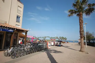 a row of bikes parked on a sidewalk near the beach at Saphir de Gruissan in Gruissan