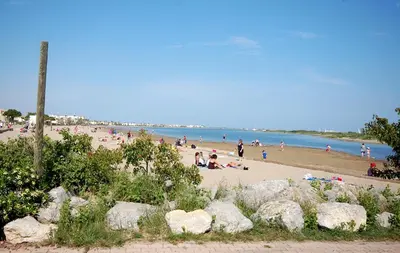 a group of people on a beach near the water at Saphir de Gruissan in Gruissan
