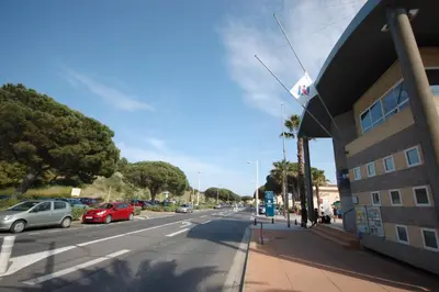 a street with cars parked on the side of a building at Saphir de Gruissan in Gruissan