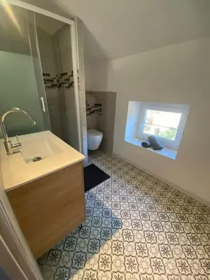 a bathroom with a sink and a toilet and a window at Douceur occitane in Saint-Chinian