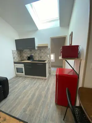 a kitchen with a stove and a red refrigerator at Douceur occitane in Saint-Chinian