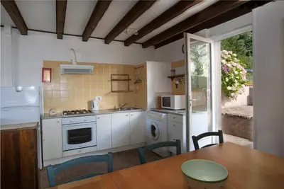 a kitchen with white appliances and a table with chairs at L'ECRIN DU LAC - L'Ortencia in Mazamet