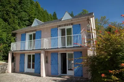 a house with blue doors and a balcony at L'ECRIN DU LAC - L'Ortencia in Mazamet