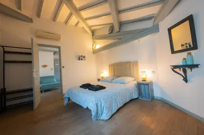 a bedroom with a bed with a blue blanket at Chez la fille de l éclusier in Castelnaudary