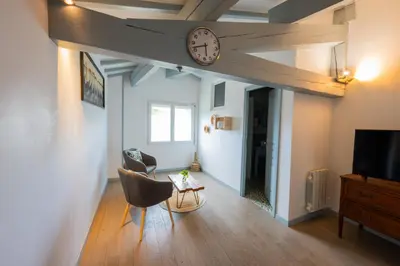 a living room with a clock on the ceiling at Chez la fille de l éclusier in Castelnaudary