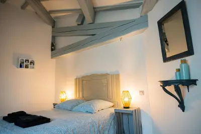 a bedroom with a bed with two lamps on it at Chez la fille de l éclusier in Castelnaudary