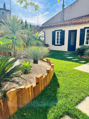 a backyard with a wooden fence and some plants at Chez la fille de l éclusier in Castelnaudary