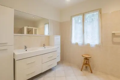 a bathroom with a sink and a mirror and a stool at Villa les cigales in Ouveillan