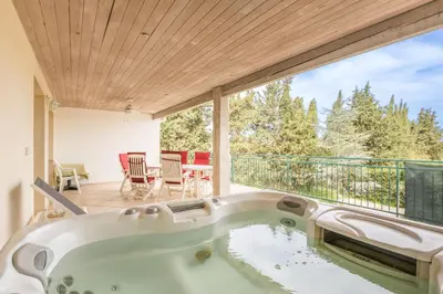 a hot tub on the balcony of a house at Villa les cigales in Ouveillan