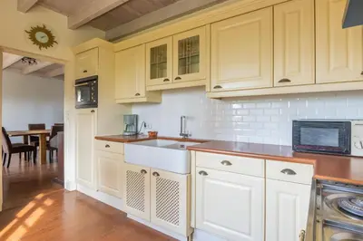 a kitchen with white cabinets and a sink at Villa les cigales in Ouveillan