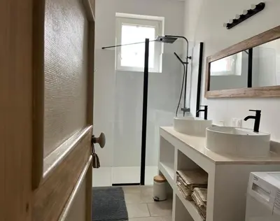 a bathroom with two sinks and a mirror at Gîtes Corbières in Montséret