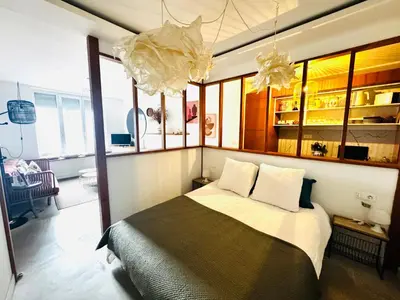 a bedroom with a large bed in a room with windows at Le trois nourrices in Narbonne