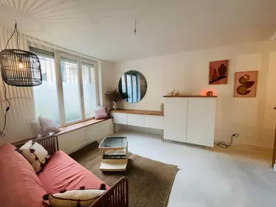 a living room with a pink couch and a mirror at Le trois nourrices in Narbonne