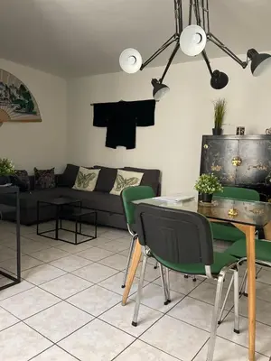 a living room with a couch and a table and chairs at Le trois nourrices in Narbonne