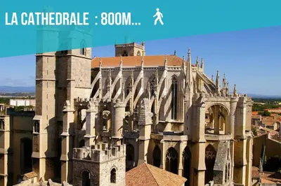 a large building with a clock tower in front of it at Le Lovely Narbonnais - Balneo & Sauna in Narbonne