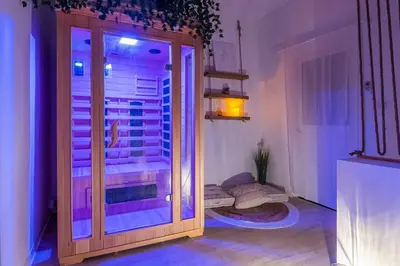 a room with a door to a balcony with purple lights at Le Lovely Narbonnais - Balneo & Sauna in Narbonne