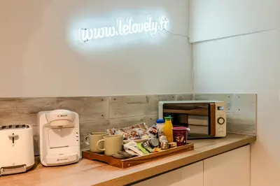 a kitchen with a counter with a microwave and appliances at Le Lovely Narbonnais - Balneo & Sauna in Narbonne