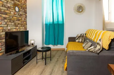 a living room with a couch and a flat screen tv at Le Cathare-Limoux-WIFI-Parking free-Oc-Keys in Limoux