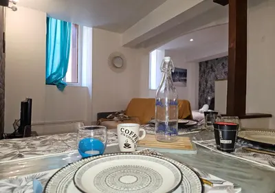 a table with a plate and a bottle on it at Le Cathare-Limoux-WIFI-Parking free-Oc-Keys in Limoux