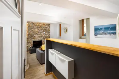 a living room with a fireplace and a brick wall at Le Cathare-Limoux-WIFI-Parking free-Oc-Keys in Limoux