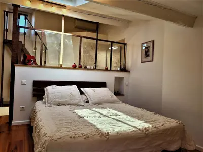 a bedroom with a large bed with white sheets at Demeure vigneronne de charme Pays CATHARE Carcassonne Jacuzzi in Blomac