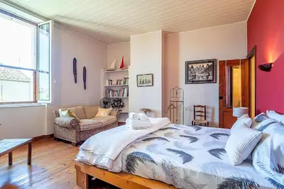 a bedroom with a large bed and a couch at Demeure vigneronne de charme Pays CATHARE Carcassonne Jacuzzi in Blomac