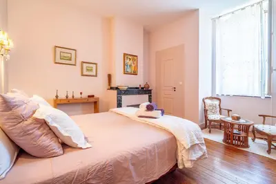 a bedroom with a large bed and a fireplace at Demeure vigneronne de charme Pays CATHARE Carcassonne Jacuzzi in Blomac