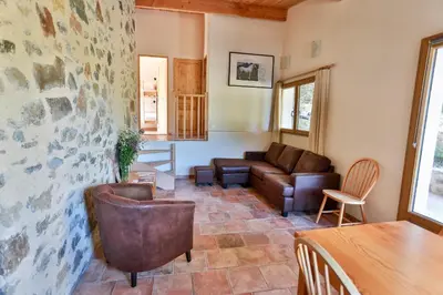 a living room with a couch and a table at Gîtes du Pont de Calmel in Rieussec
