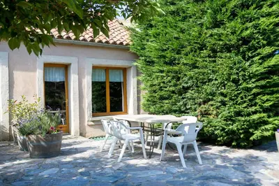 a table and chairs in front of a house at Gîtes du Pont de Calmel in Rieussec