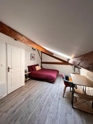 a bedroom with a red bed in a attic at Beau T4 au cœur du centre ville in Narbonne