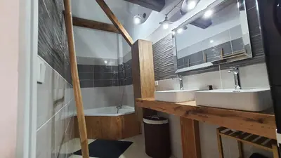 a bathroom with two sinks and a mirror and a tub at Beau T4 au cœur du centre ville in Narbonne