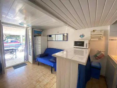 a small kitchen with a counter and a microwave at La Maison Bleue in Gruissan