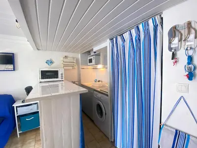 a small kitchen with a washer and dryer in a room at La Maison Bleue in Gruissan