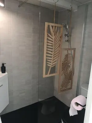 a bathroom with a shower with a toilet and a towel at La Maison Bleue in Gruissan
