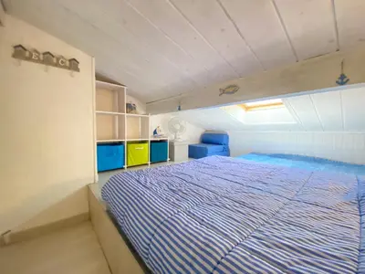 a bedroom with a bed with a blue comforter at La Maison Bleue in Gruissan