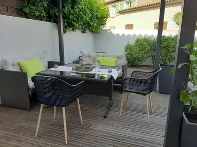 a patio with a table and chairs on a deck at Chambre double dans maison chaleureuse et familiale in Carcassonne
