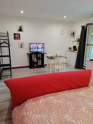 a living room with a red couch and a table at Charmant logis au coeur de Mirepoix in Mirepoix