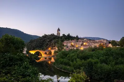a town on a hill with a bridge over a river at MAISON ST LAURENT in Olargues