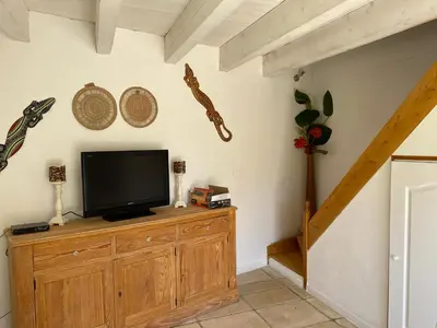 a living room with a tv on a wooden cabinet at Les Plages Haute in Peyriac-de-Mer