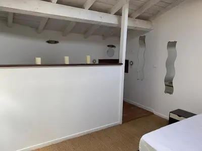 a room with a white wall and a bed at Les Plages Haute in Peyriac-de-Mer