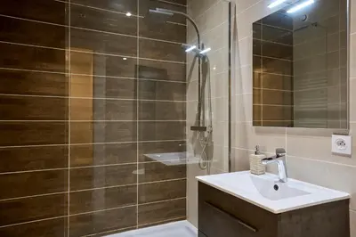 a bathroom with a shower with a sink and a mirror at Le DONJON DIONYSOS - Love Room in Carcassonne