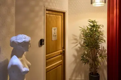 a statue next to a door with a plant at Le DONJON DIONYSOS - Love Room in Carcassonne