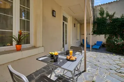 a table with a bowl of fruit on a patio at Le DONJON DIONYSOS - Love Room in Carcassonne