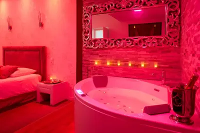 a red bathroom with a tub and a bed at Le DONJON DIONYSOS - Love Room in Carcassonne