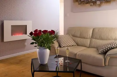 a living room with a couch and a vase with flowers on a table at Le DONJON DIONYSOS - Love Room in Carcassonne
