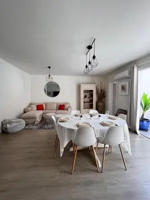 a white living room with a table and a couch at Gorgeous town house in Narbonne
