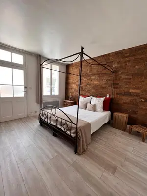 a bedroom with a bed and a brick wall at Gorgeous town house in Narbonne