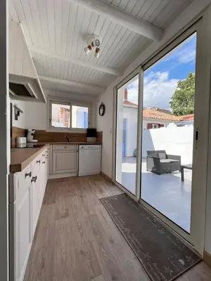 a kitchen with white cabinets and a large window at Gorgeous town house in Narbonne